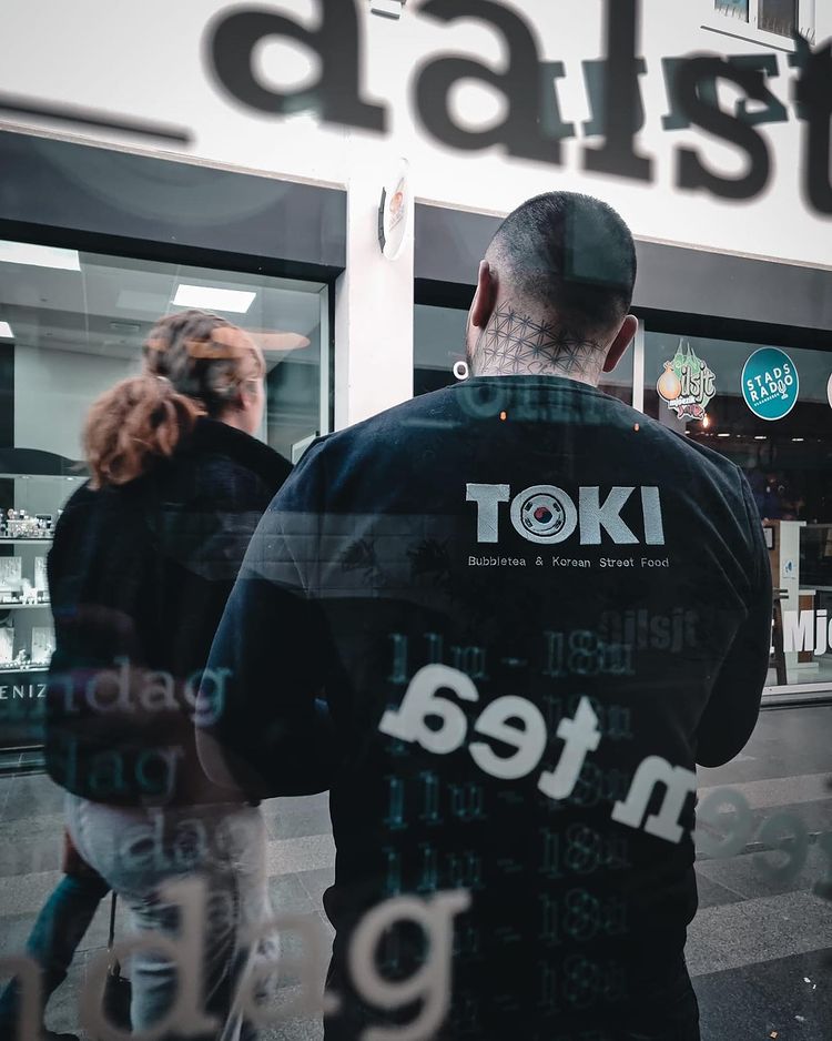 Man in black 'Toki' shirt